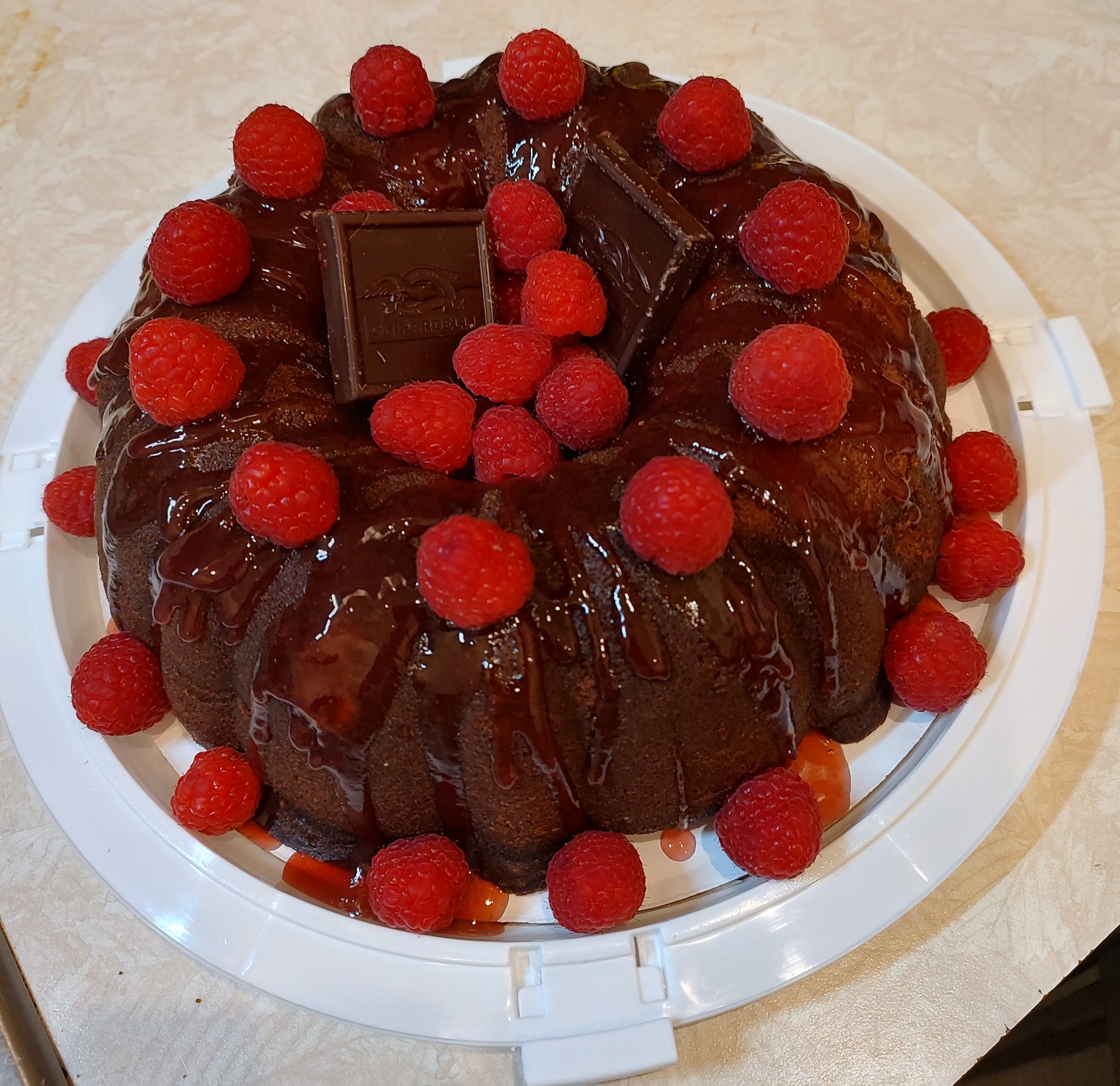 Chocolate bundt cake topped with raspberries and chocolate pieces