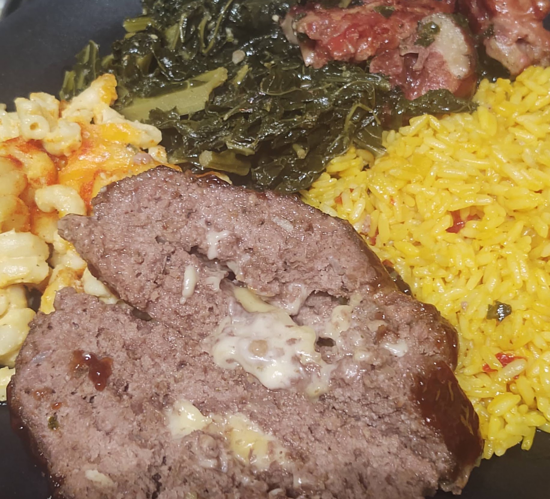 Southern comfort plate with meatloaf, collard greens, yellow rice, and mac and cheese